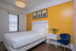 a bedroom with a white bed and a blue chair at Edwardian Hotel in San Francisco